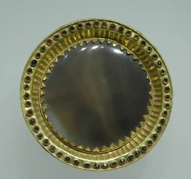 Gold disc with red stones around